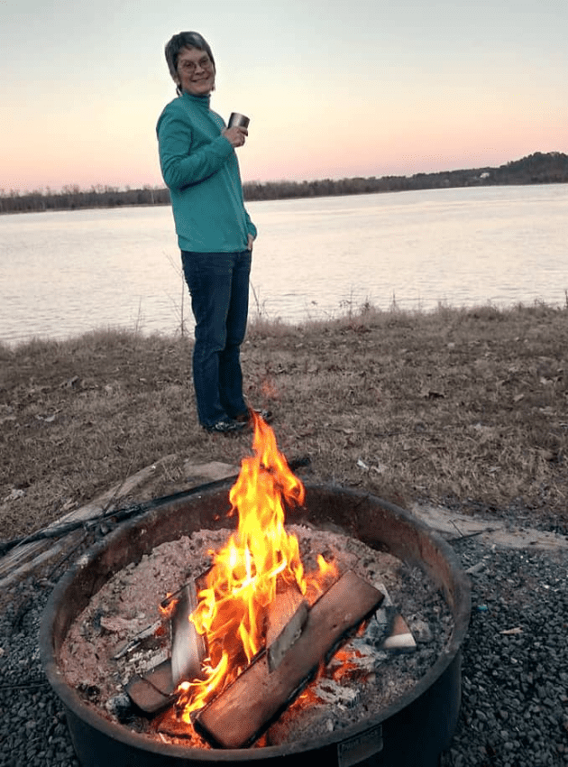 Gib Berryhill by lake with a camp fire
