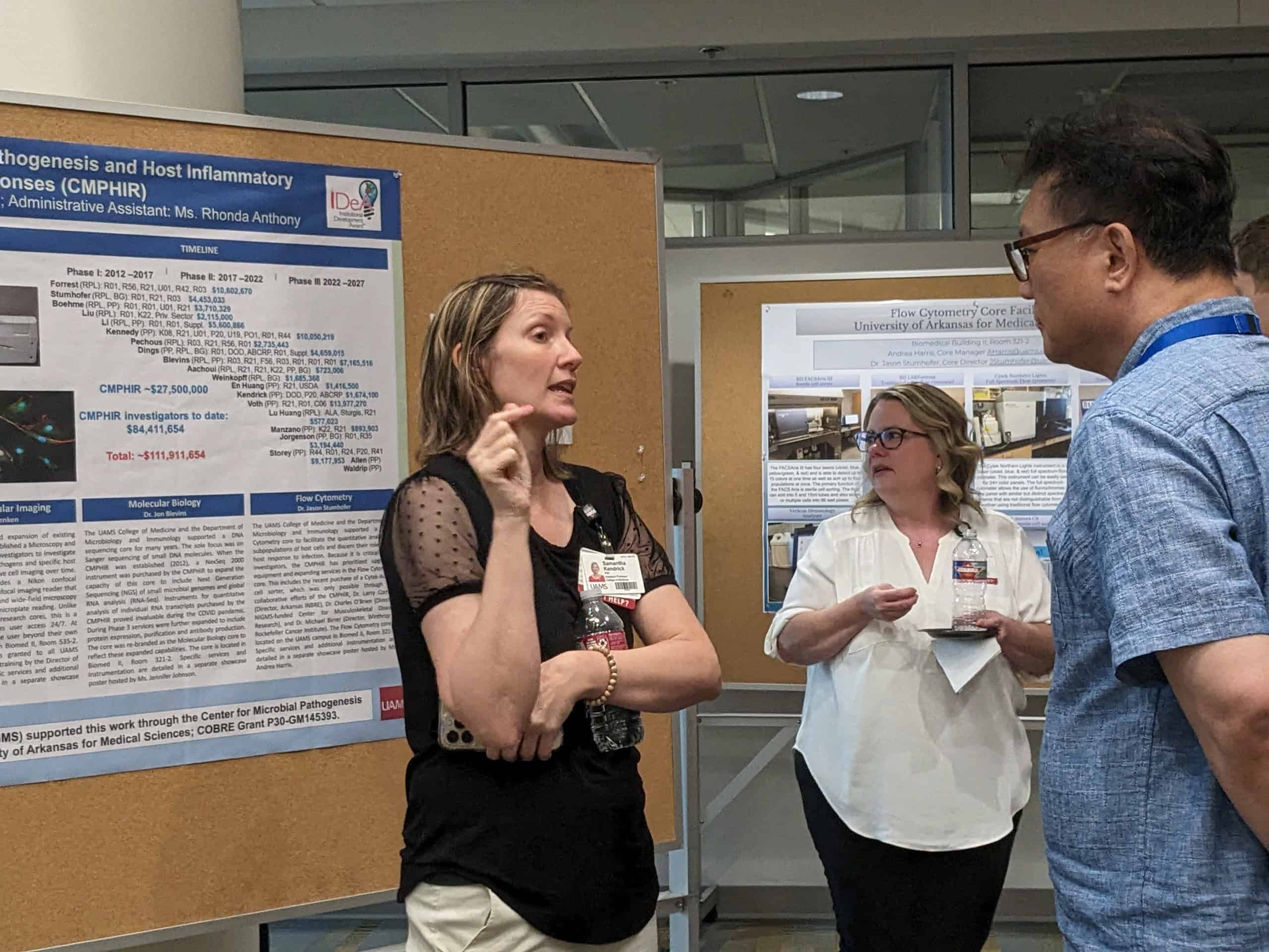 3 people staning in front of a poster talking