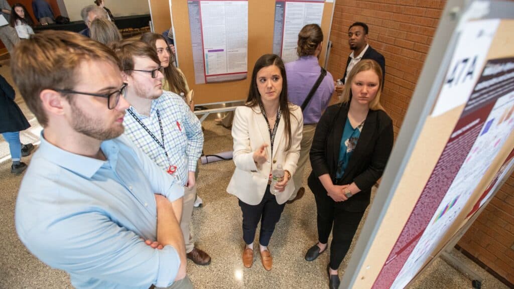 Several students standing in front of a poster