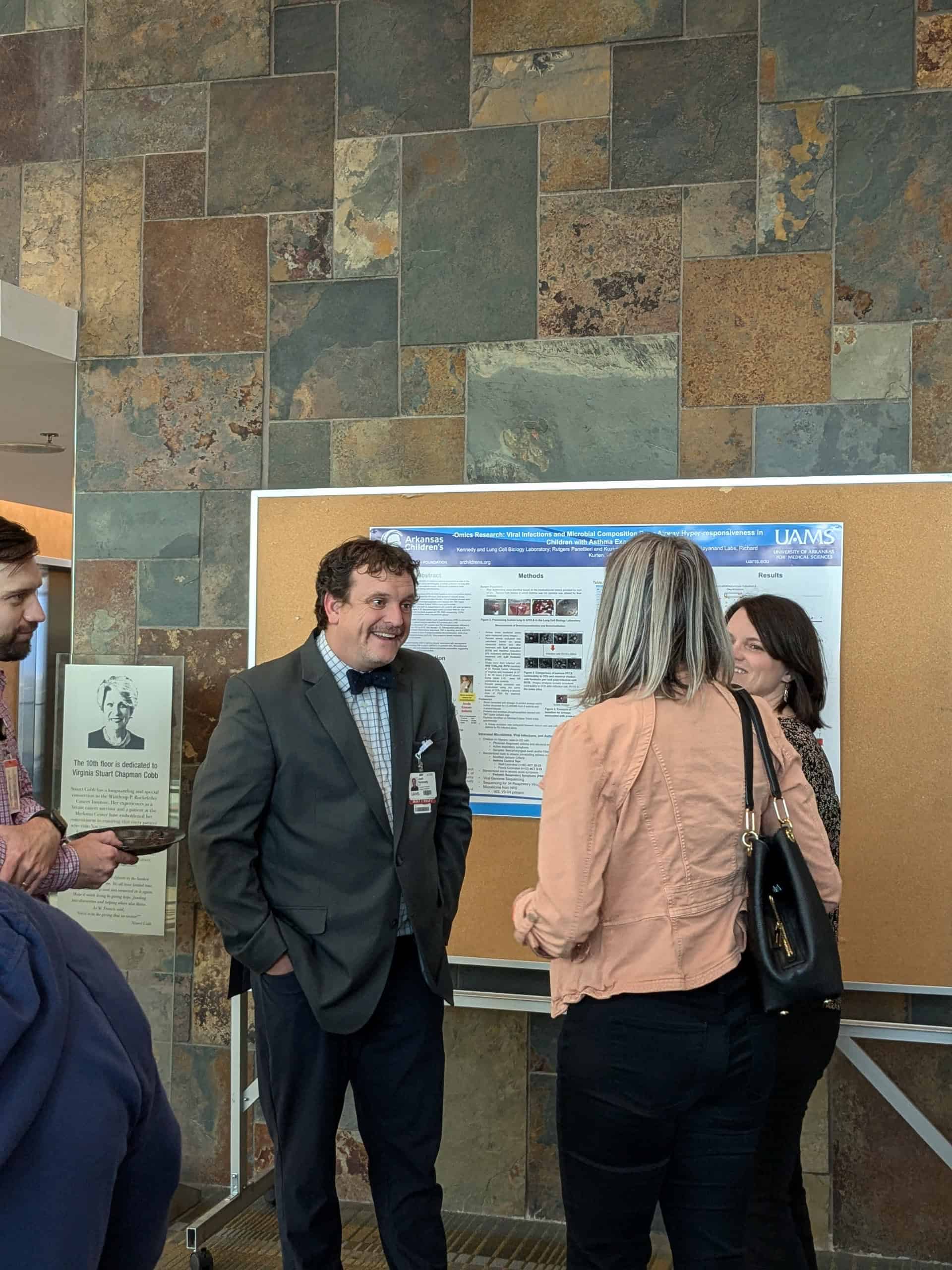 Photos of presenters showing their poster