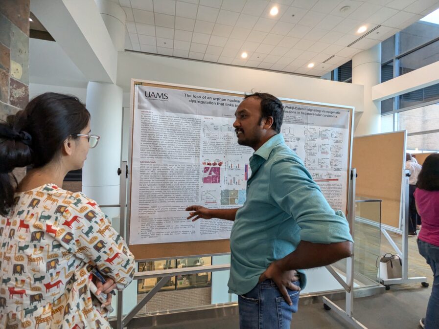 A researcher is pointing to a poster